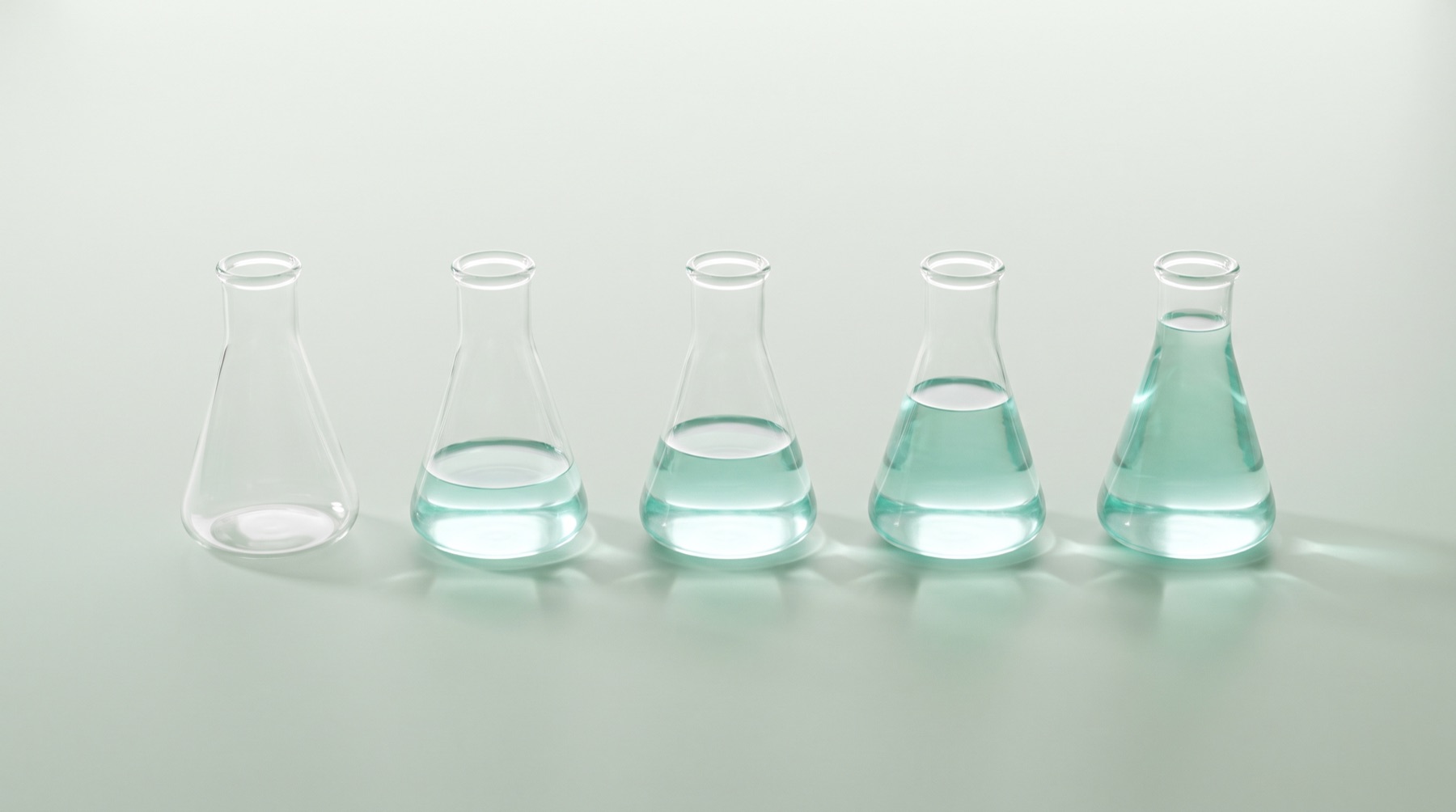 Five laboratory flasks filled with teal liquid at increasing levels, from nearly empty to full